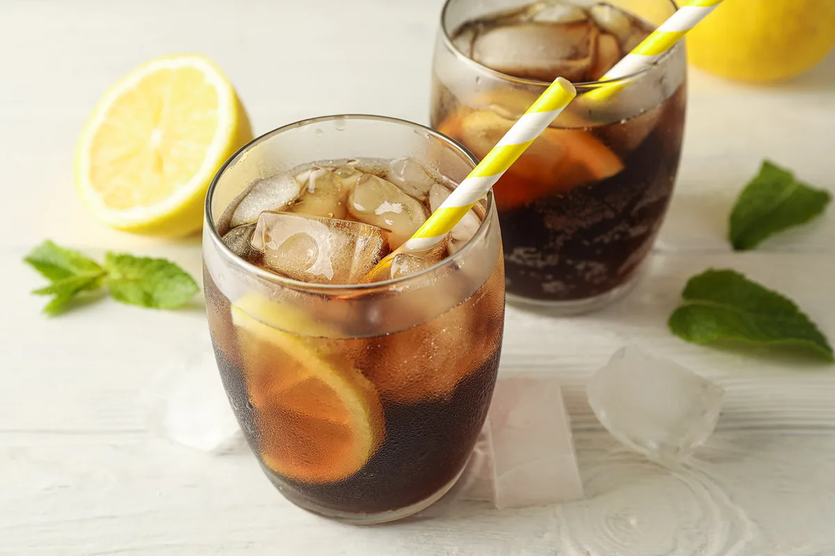 A glass of a cold drink with ice cubes